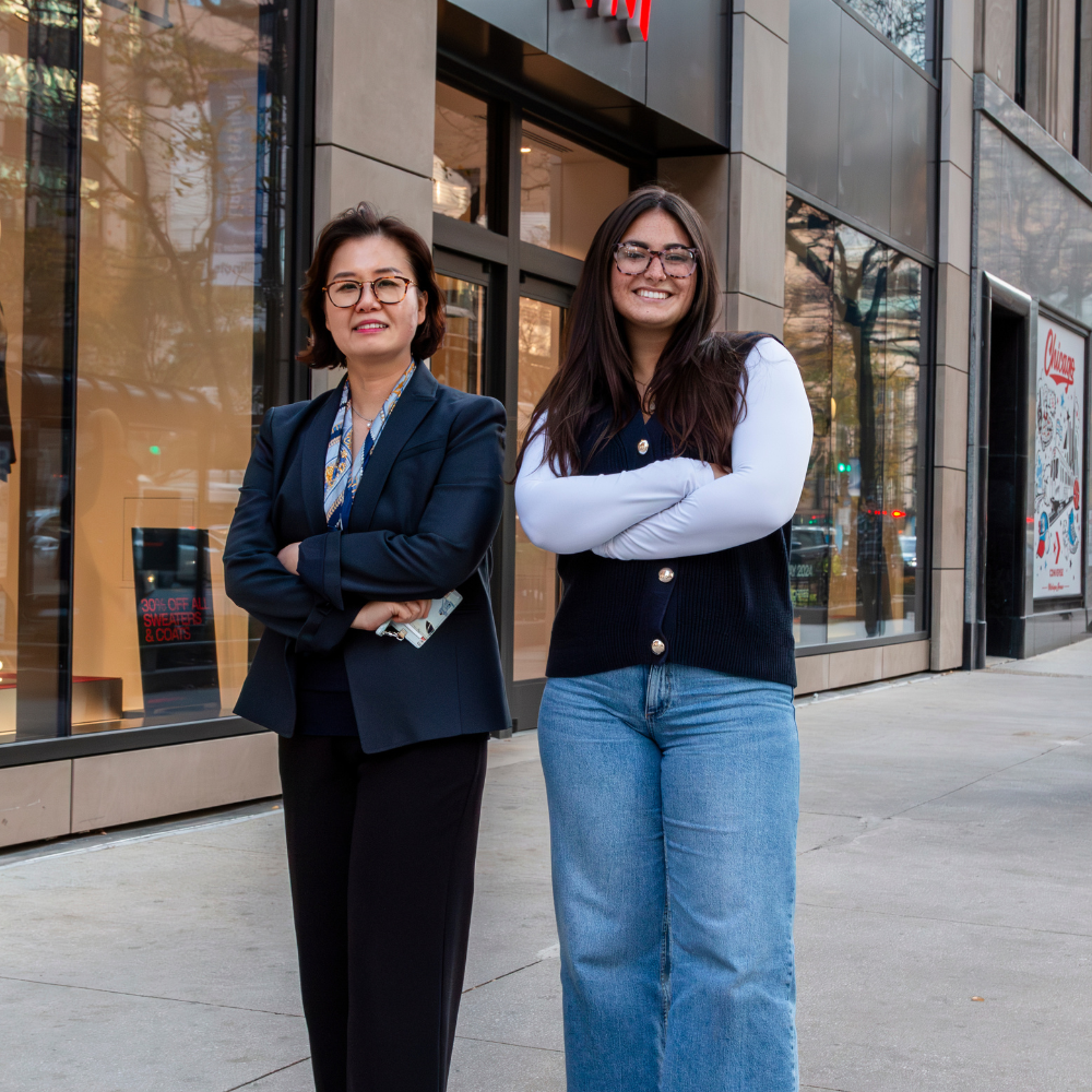 Loyola Chicago student Avery Robbins and Professor Chris Yim posing smiling downtown